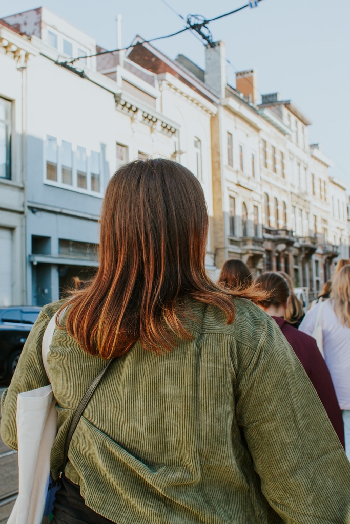 An au pair walks down a cute street in Antwerp in the morning sunshine. Conditions to au pair in Belgium.