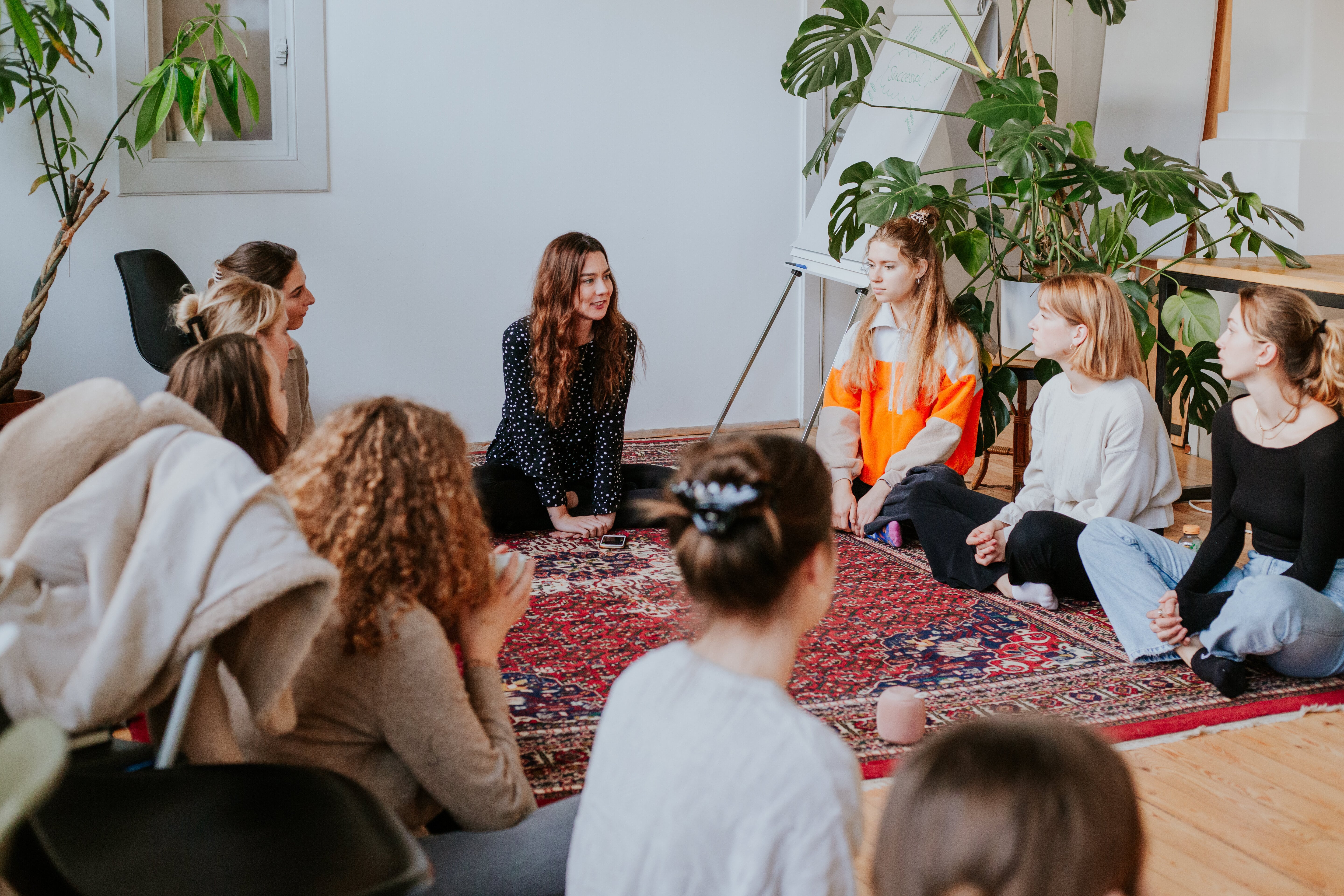 Learn more about us and our team with Nina teaching one of her courses to a group of au pairs and nannies sitting on the ground