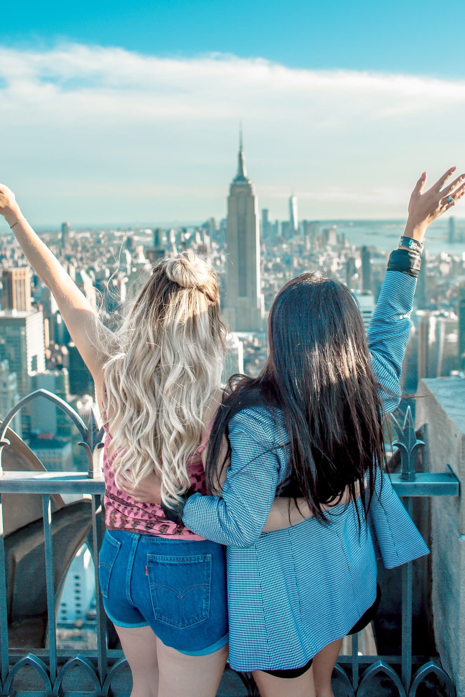two au pairs pose in front of the empire state building in new york city during their au pair stay in america. wil jij au pair worden in amerika net zoals deze meiden