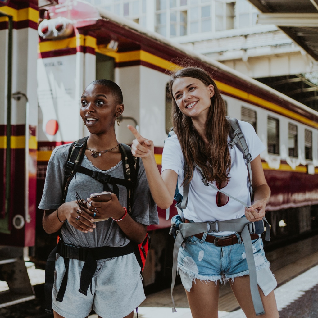 Two friends stand at a train station in Spain during their time as au pairs.