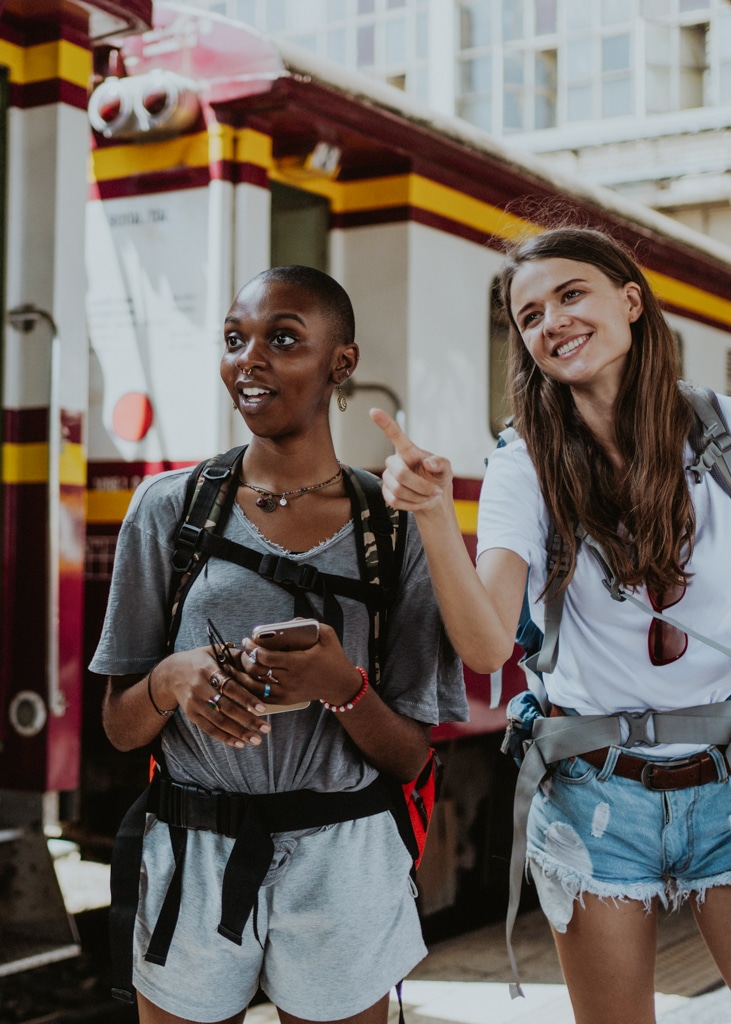 Two friends stand at a train station in Spain during their time as au pairs. Conditions to au pair in Spain.