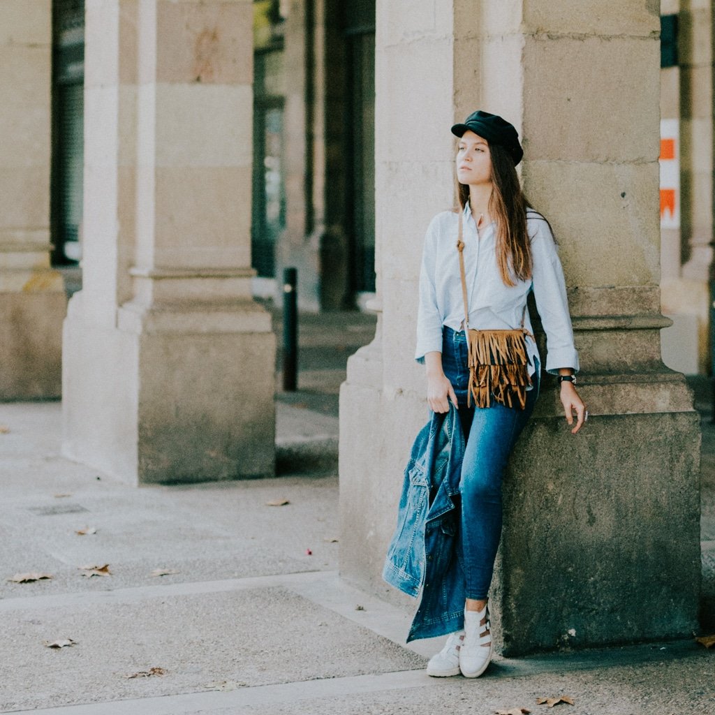 An au pair poses by a beautiful column in an old square in Italy.