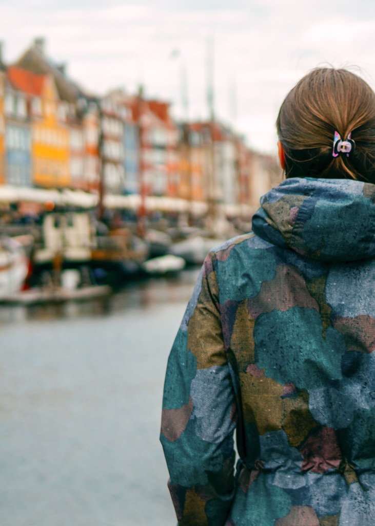 An au pair looks across Nyhavn, a 17th-century waterfront, canal and entertainment district in Copenhagen, Denmark. Conditions to au pair in Denmark.