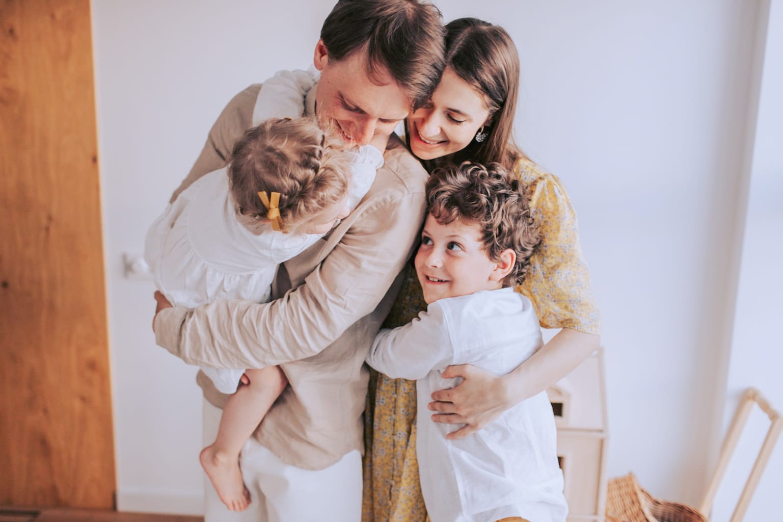 A host family in the UK with two parents hugging their two children.