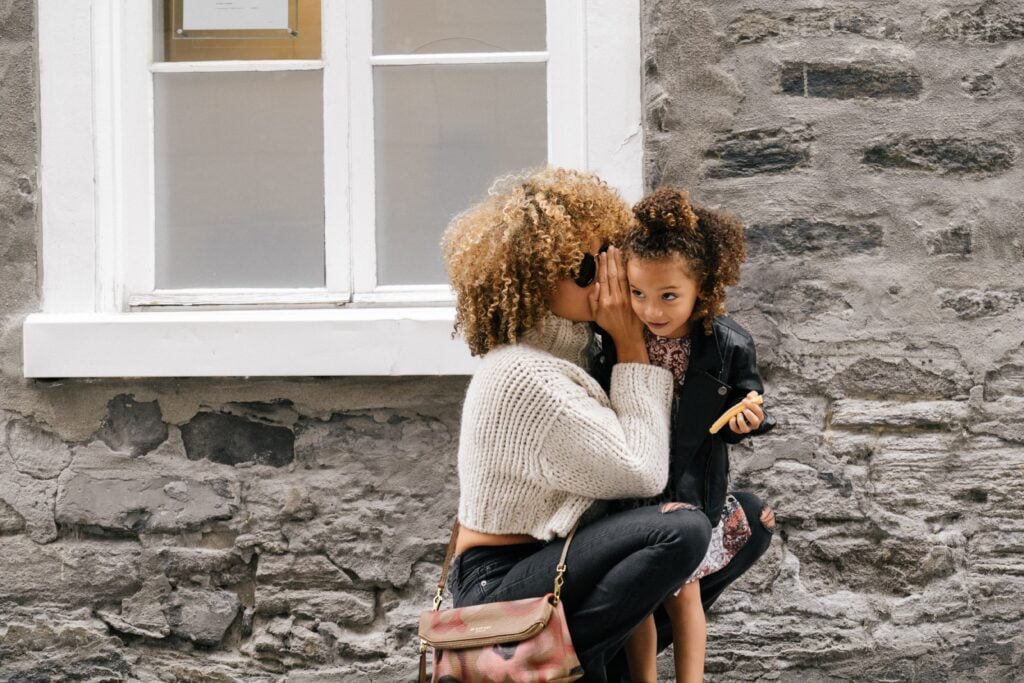 An au pair plays with her host child outside.