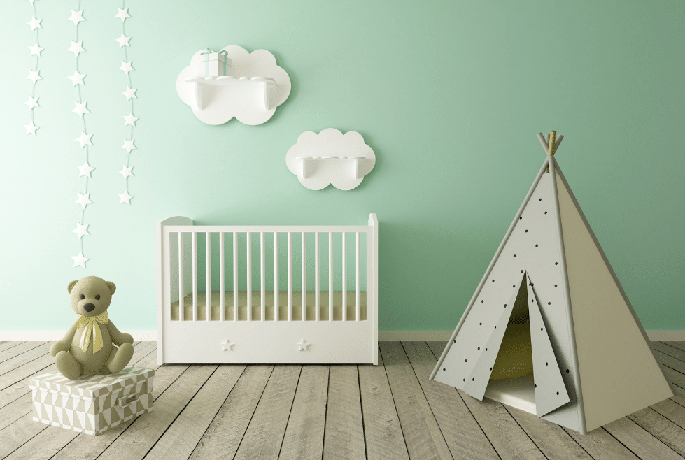 babykamer met groenen muur en witte meubels waaronder wolken aan de muur een bed en recht een tent
