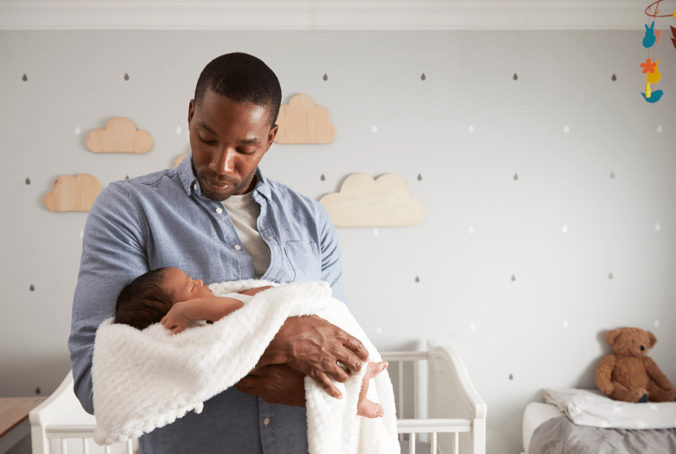 Vader met een baby in een slaapkamer werkende aan de slaapcyclus van de baby