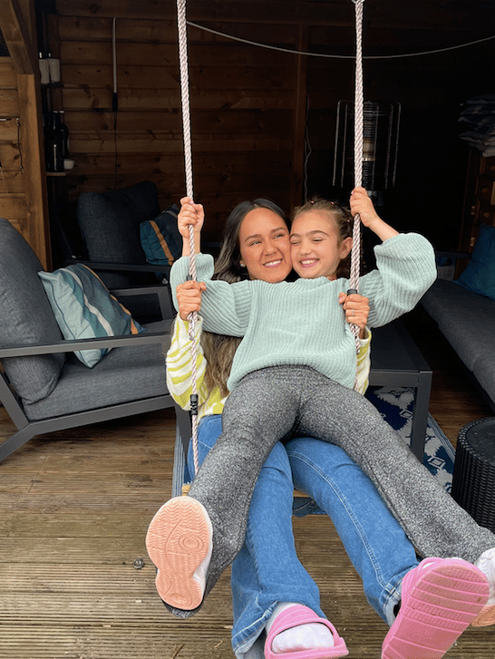 au pair samen met haar host kid op de schommel in de achtertuin