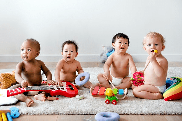 babys nebeneinander in einer reihe mit spielzeuginstrumenten
