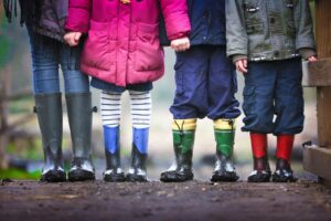 kinderen die in de herfst buitenspelen in het bos en helemaal vies zijn