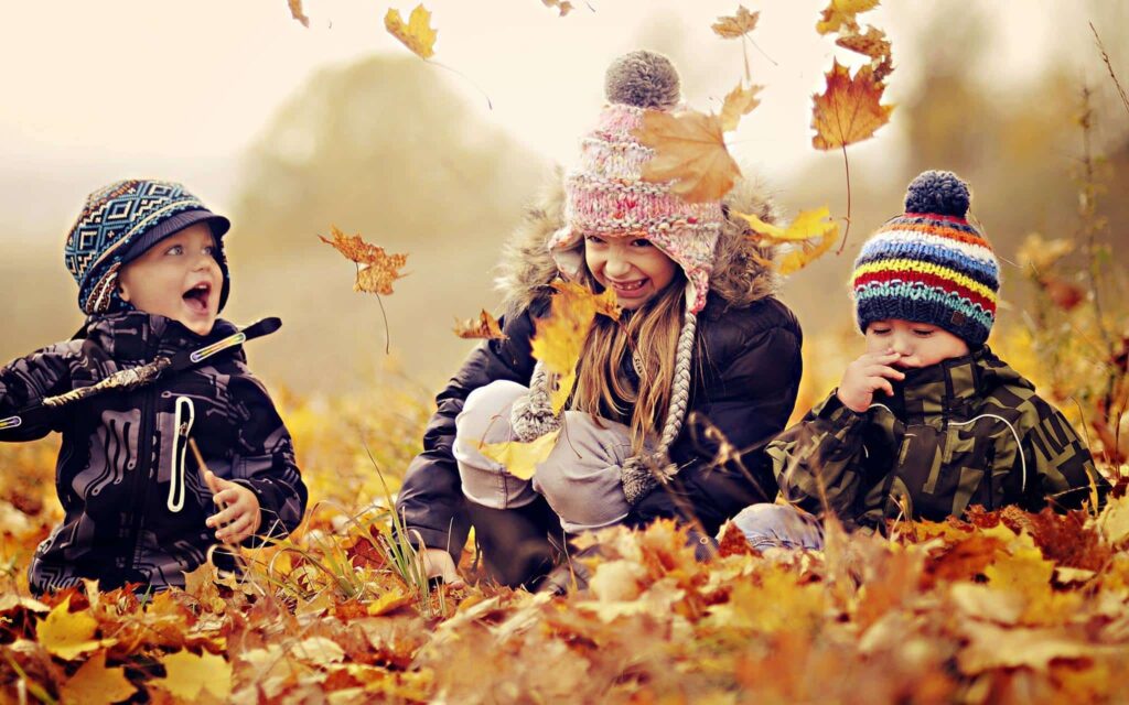 kids playing with leaves in the fall
