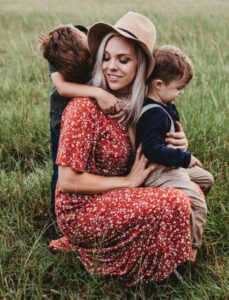 Oppas van Nanny Nina samen met haar oppaskindjes in een grasveld