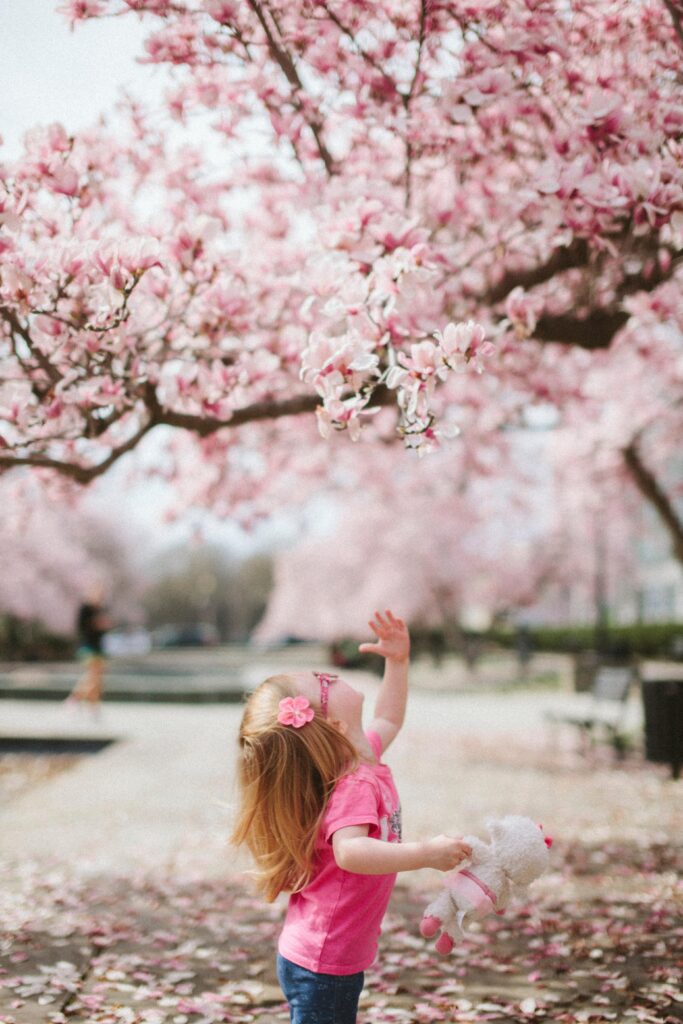 Niño en primavera con flores rosas