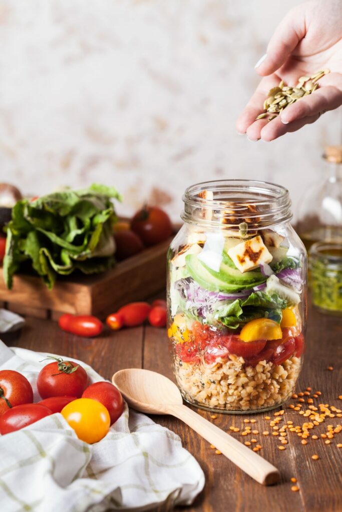 pot met verschillende soorten groenten erin daar omheen ook verschillende soorten groenten om te laten zien wat gezond eten voor kinderen is