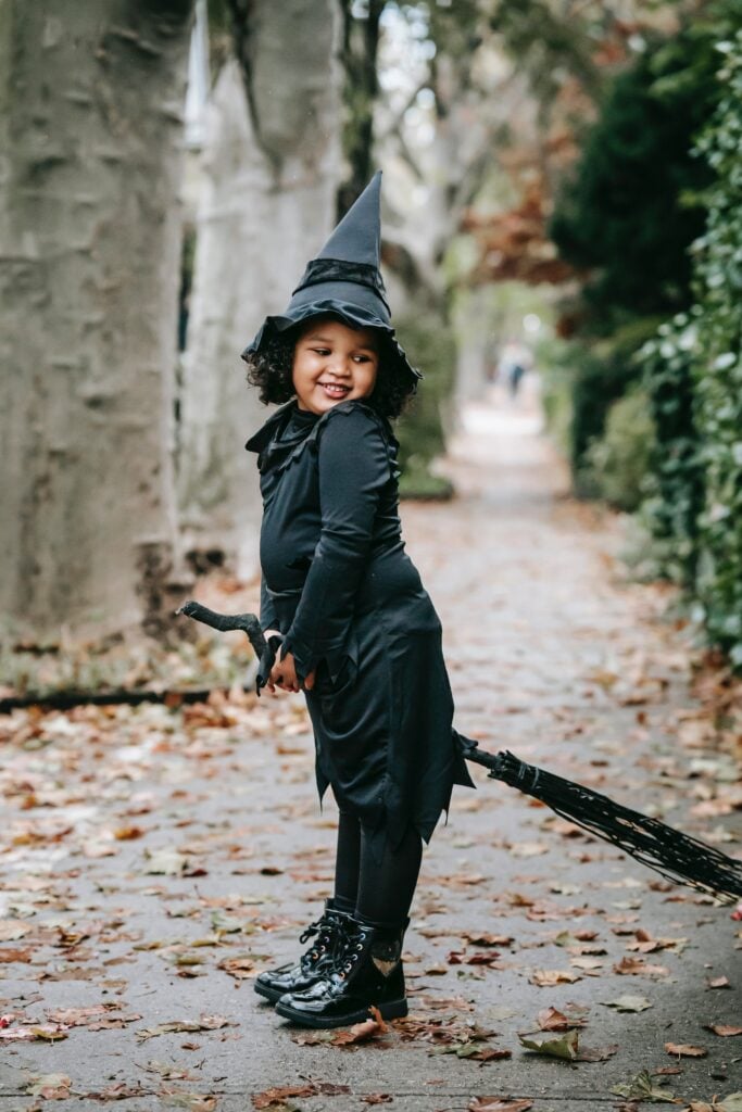 meisje in zwarte halloween outfit. heksen outfit op bezem
