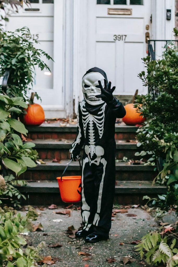 Halloween outfit skelet. jongentje in skelet outfit met halloween emmer


