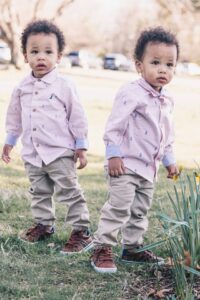 tweeling jongens buiten met dezelfde kleding aan