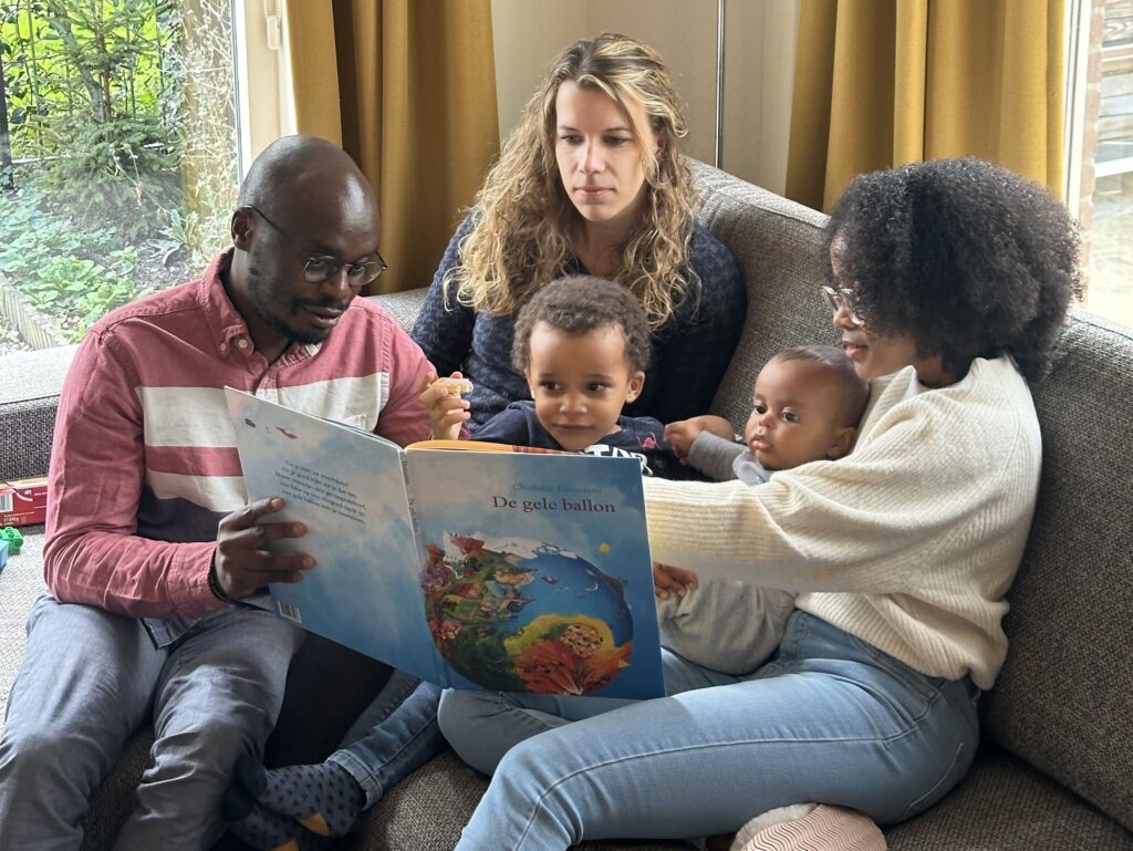 eine familie, die einem kind etwas aus dem buch zeigt